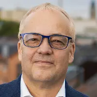 Jens Beckert headshot. He is wearing glasses, a white shirt and a blue suit jacket.