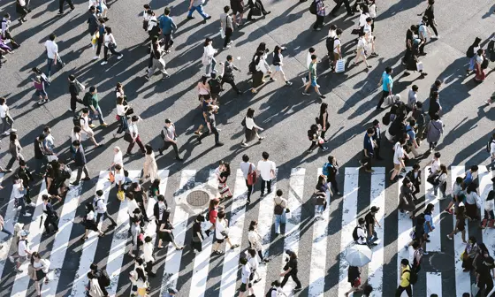 People walking at a busy street crossing.