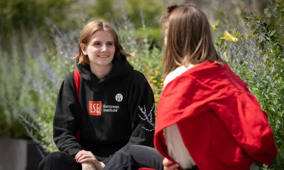 Two students chatting on a bench