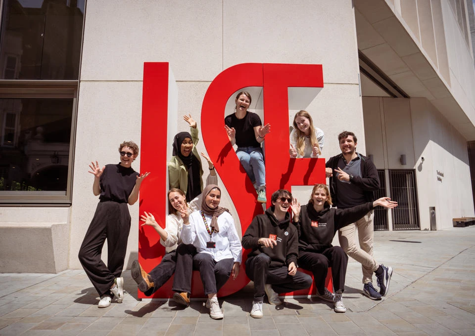 Students standing in front of LSE sign