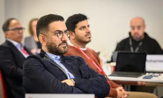 Man with arms crossed looks at presentation