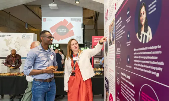 A researcher shows an exhibition visitor her research
