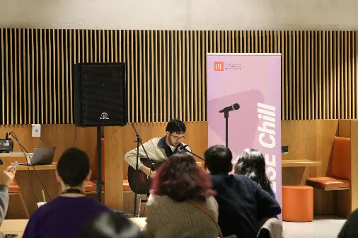 student performing guitar and singing at LSE Chill