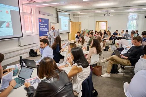 Nilesh Dattani lecturing a classroom of students