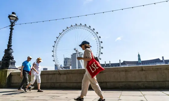 Woman with LSE bag walking on thames path