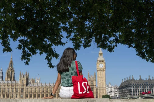 Girl sitting with lse bag facing westminster