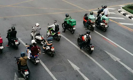 A group of people on motorbikes waiting at a crossroads
