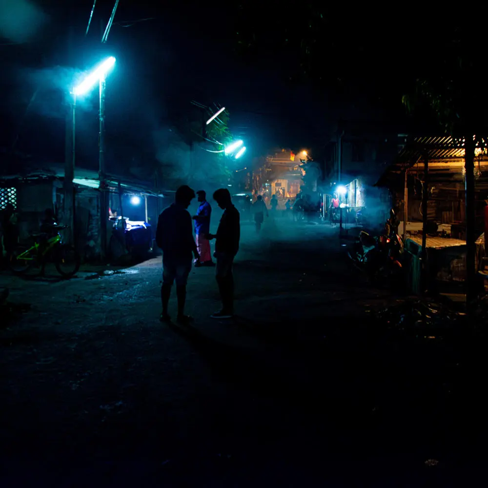 Don slater research scene - a dark street with bright blue lighting and figures