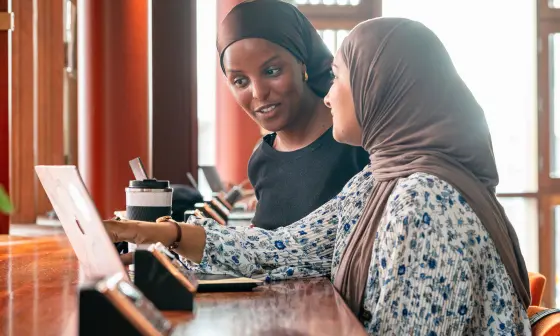 Two students looking at a laptop