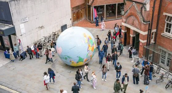 Students walk past the globe on LSE campus during Welcome