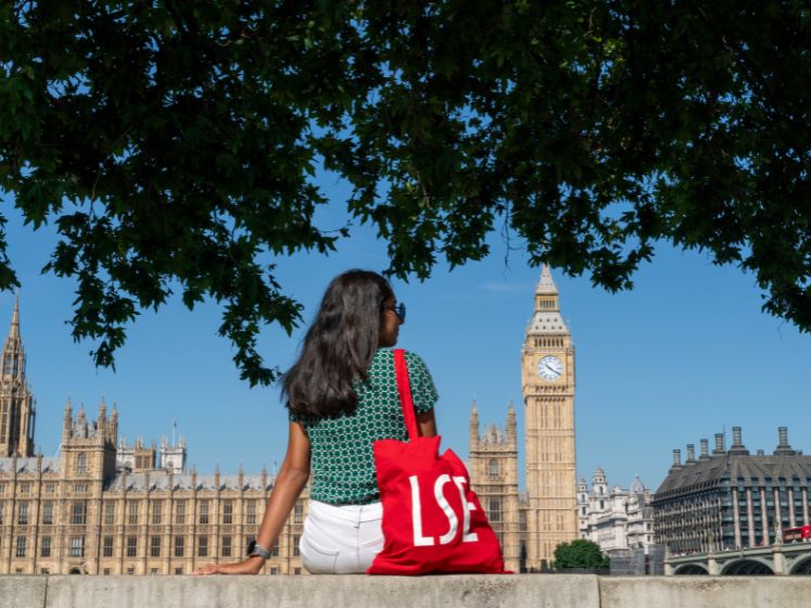 4-3 student with lse bag looking across the river at the houses of parliament 747x560px