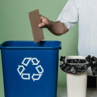 person putting rubbish into recycling bin image sourced from pexels