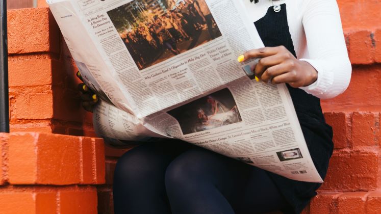 person reading newspaper 420