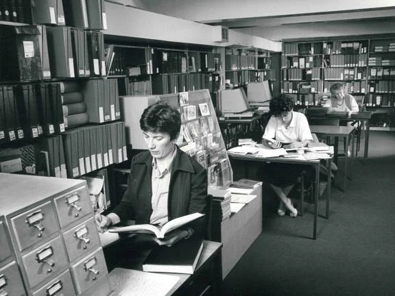 People sitting at individual desks doing research.