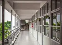 A long school hallway with classrooms on one side and balcony on the other