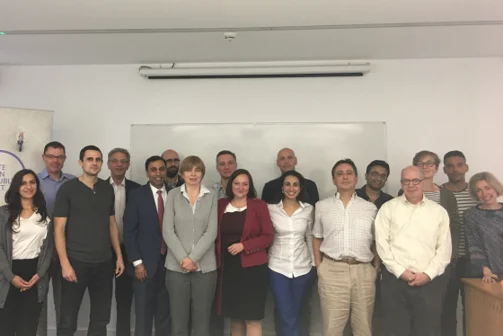 A group of academics stood in front of a blank whiteboard