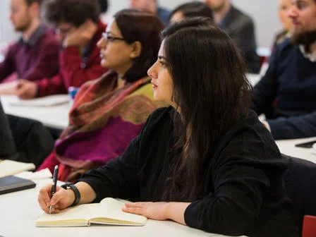 People in a seminar taking notes