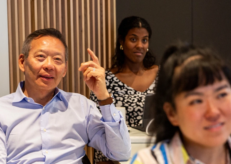 Diverse group of EMSBE students engaged in classroom discussion at LSE, with participants seated around a table in a modern learning environment.