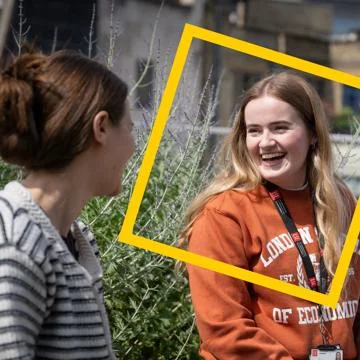 Woman in orange LSE jumper smiling