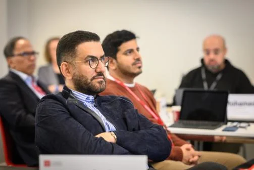 Man with arms crossed looks at presentation