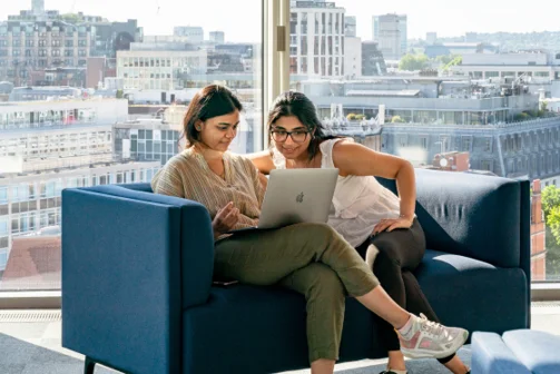 To students on a sofa looking at a laptop