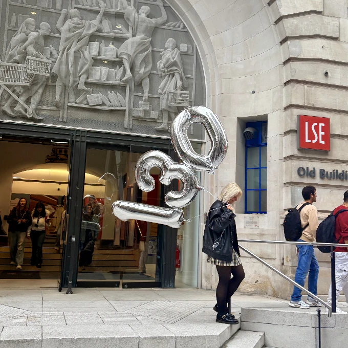 A girl carries silver 130 balloons