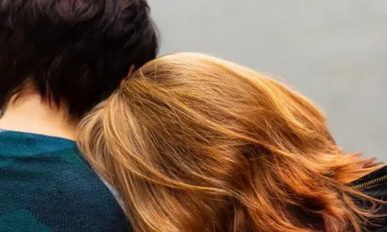 Two people leaning on each other