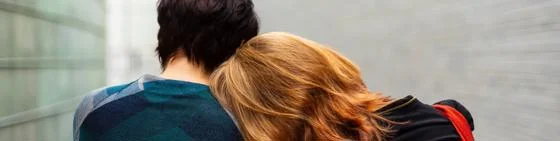 Two people leaning on each other