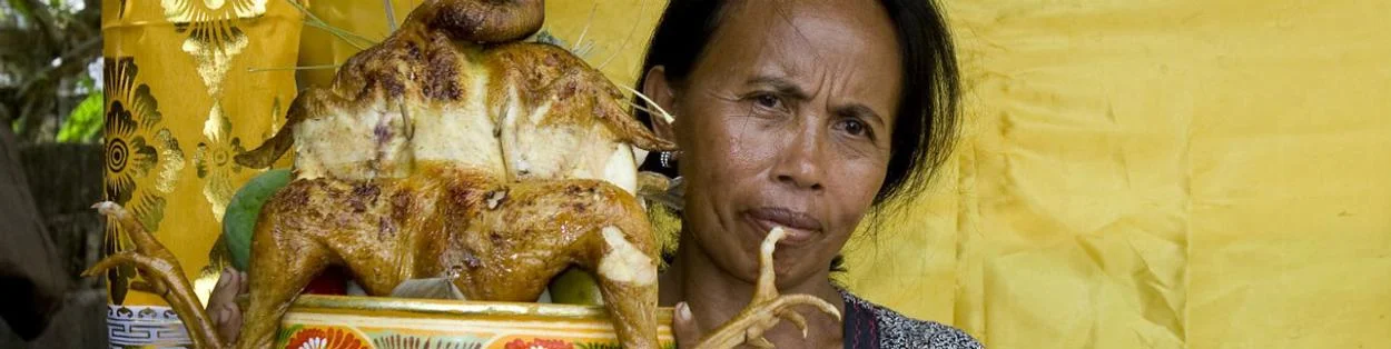 a woman holding a cooked chicken