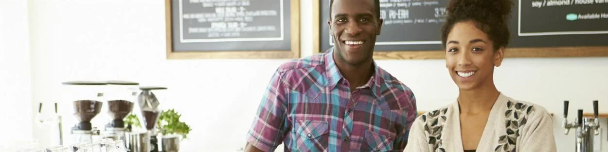 a man and woman serving in a coffee shop