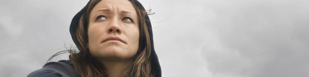 a sad-looking woman looking into the distance