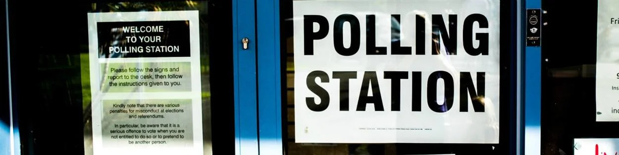 A door with a 'polling station' notice.