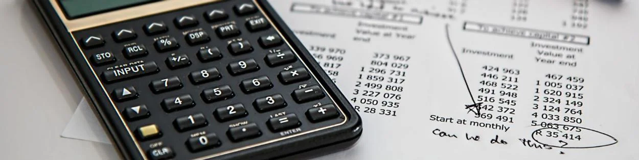 A calculator and paper with sums on.