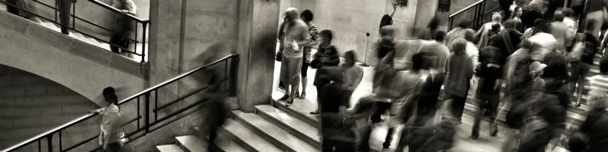 People inside a building walking up and down stairs.