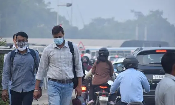 People wearing face masks walking along the Delhi Dwarka - Mumbai Expressway in Gurugram, India