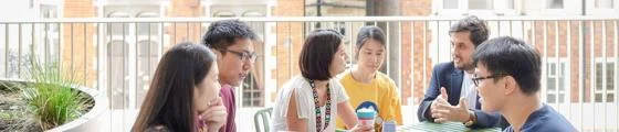 Group of students sitting on a Marshall Building Terrace deep in conversation.