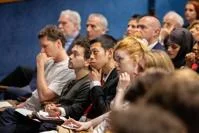Audience in lecture theatre pondering talk