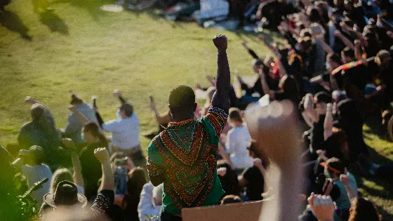 Protestors at a meeting raising their arms in solidarity