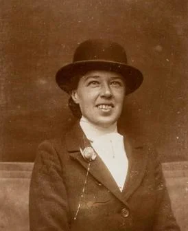 Vera 'Jack' Holme portrait. Smiling and wearing a bowler hat