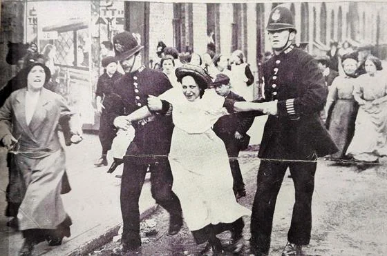 A woman being arrested by police.