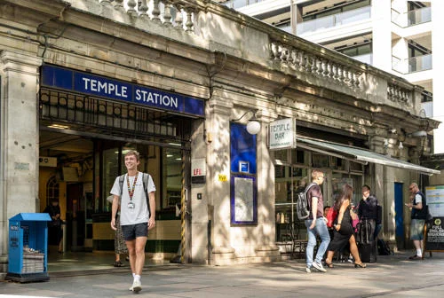 Commuter student walking out of Temple tube station towards LSE campus