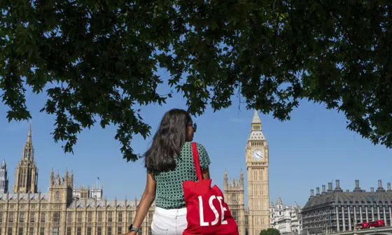 Girl sitting with lse bag facing westminster