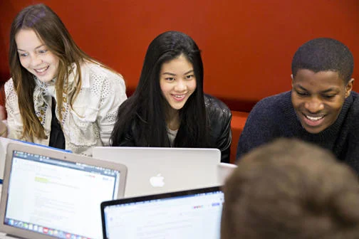 LSE students working on their laptops on campus