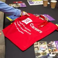 red tote bag with LSE Careers information on it