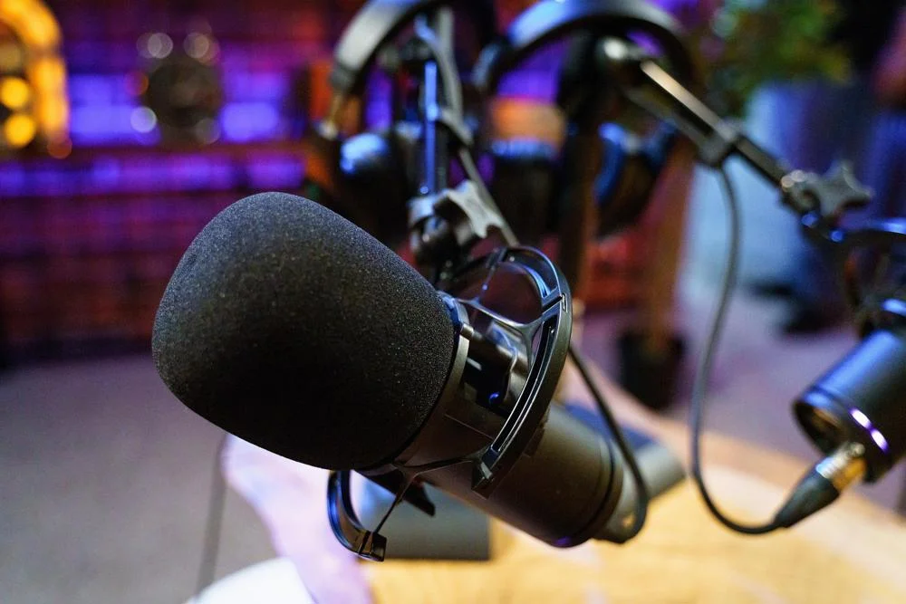 Podcast microphone with coloured lights behind. Image by Gigxels.com from Pixabay