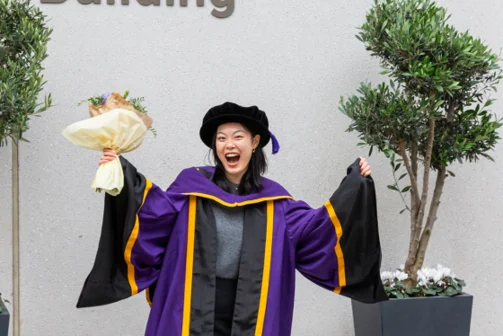 A PhD student celebrating at graduation