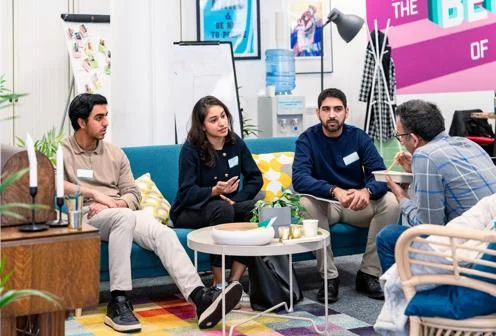 Four people sit and talk in LSE's Generate''s hub, the Gen Den