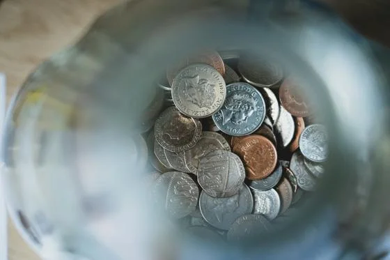 A view looking down into money in the bottom of a coin jar