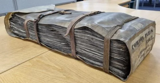 Historic volume containing legal records, bound with leather straps