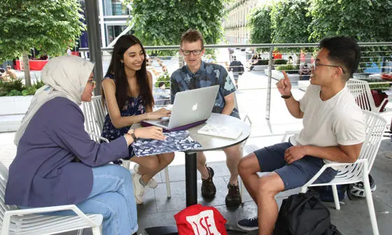 Research students around table on campus